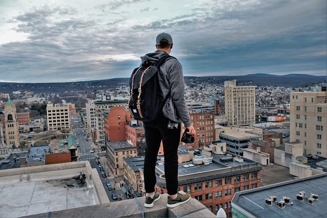 A photographer standing on a rooftop overlooking a city | Millennials career adjustments
