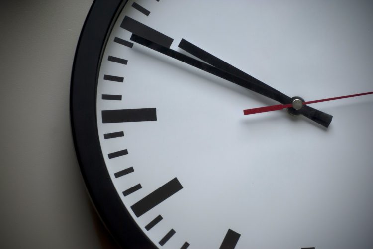 A black and white clock hanging on a wall| new DOL overtime rule 2019