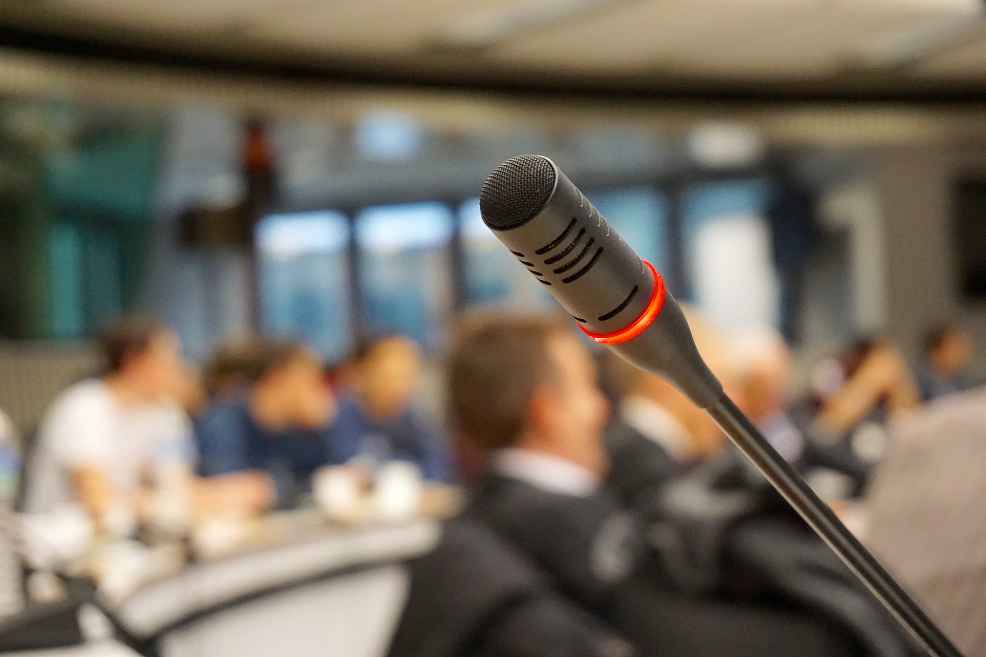 A microphone in a conference room filled with people