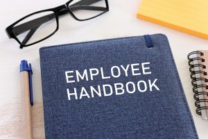 Employee handbook with glasses and a pen